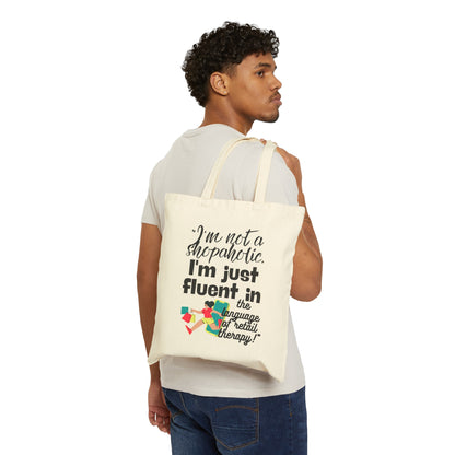 "I'm not a shopaholic; I'm just fluent in the language of retail therapy!"- Cotton Canvas Tote Bag